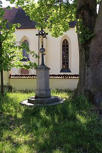 Kříž v parku nedaleko sochy.