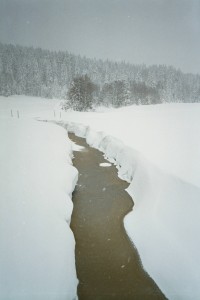 Kvildský potok se jen těžce probíjí sněhovými závějemi před Kvildou.