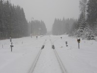 Sněhové vločky zasypávají železniční křižovatku