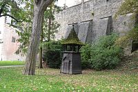 Dřevěná zvonička v Bezručových sadech, vzadu městské opevnění