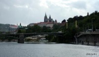 Plavba po Vltavě na lodi Czech Boat - Ohlédnutí na Pražský hrad přes Čechův most, pod ním je vidět Občanskou Plovárnu, za ním zelená kopule Strakovy akademie.