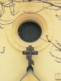 dřevěný kříž a okno nad vchodem