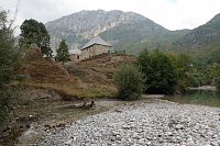 Budova staréš školy v Cureaj i Epërm z pohledu od brodu.