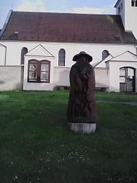 16. Dřevěná socha před kostelem připomíná mýty o obci.