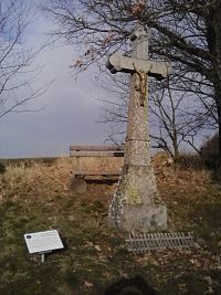 46. Kamenný kříž s lavičkou u cesty k Ředicím.