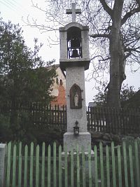 7. Z kamene tesaná zvonička z roku 1905 ve Veletíně, v jejíž přední části je zašpičatělý výklenek se soškou sv. Jana Nepomuckého.