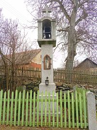 35. Z kamene tesaná zvonička z roku 1905 ve Veletíně, v jejíž přední části je zašpičatělý výklenek se soškou sv. Jana Nepomuckého