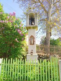 4. Z kamene tesaná zvonička z roku 1905 ve Veletíně, v jejíž přední části je zašpičatělý výklenek se soškou sv. Jana Nepomuckého