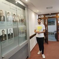 Průvodce u stěny s fotografiemi bývalých starostů včetně toho současného