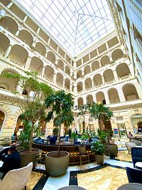 Příjemné atrium hotelu Anantara New York Palace, v jehož prostorách kavárna sídlí.