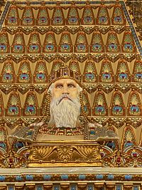 Na dekorativně pojatém krbu stojí busta sv. Štěpána.