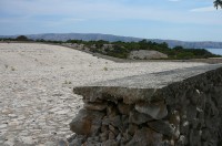 Velká plocha na svádění dešťové vody, vzadu nápis: kamen na kamen opět samo kamen 