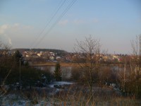 pohled na Dubeč z trasy naučné stezky - v popředí rybník V Rohožníku, dýmajíccí komín na obzoru patří Malešické spalovně