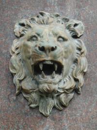 Jedna ze dvou lvích hlav na boku podstavce