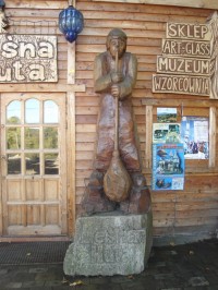 Dřevěná socha skláře u vchodu do prodejny