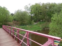 Růžový ocelový most přes řeku Kamienna