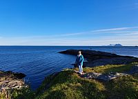 Na okraji obce si prohlížíme drsné skalnaté pobřeží i vysoké kopce.