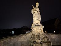 Historická socha na historickém mostě poblíž historické radnice.