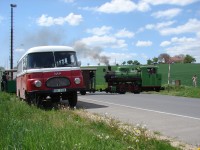 Historický autobus Robur a parní vlak na přejezdu před branou do muzea ve Zbýšově 