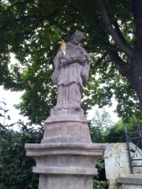 22.U kostela stojí socha sv.Jana z Nepomuku