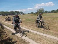 vojaci v dobových uniformách na bicykloch