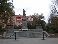 socha na konci parku, za ním Faustov dom