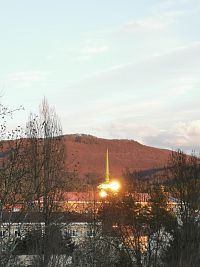podvečerný pohľad na budovu slobodárne, za ňou Strážovské vrchy