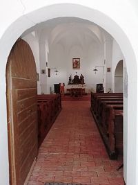 pohľad do kostola, loď je oddelená dvoma schodíkmi od presbytéria
