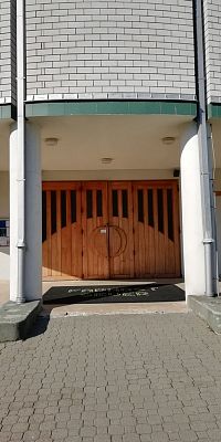 veľké drevené vchodové dvere ozdobené sklom