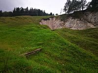 zelená tráva a skaly bývalého kameňolomu