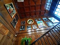 portréty na drevenom podklade, schodisko vedúce k pokladni galérie