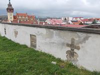 múr pri kostole s náhrobnými kameňmi