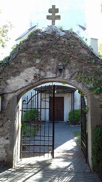 vstupná brána cez múr, ktorý ohraničuje areál kostola