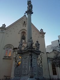 morový stĺp, v niké priečelia kostola je socha patróna kostola, dielo Antona Brandla