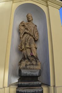 socha Jána Nepomuckého vo výklenku pred vchodom do areálu cintorína a kostola