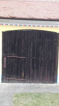 brána s menšími vchodovými dverami a malým maľovaným zdobením pod strechou