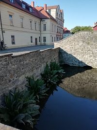 pohľad na umelú vodnú nádrž, za ňou schody k severnému portálu