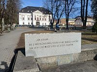 doska, súčasť pamätníka, v pozadí kaštieľ