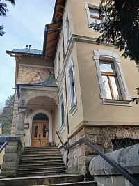 vchod do vily s kvetinovou výzdobou pri dverách