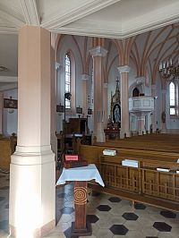 pohľad k jednému bočnému oltáru a kazateľnici, na stene obrazy krížovej cesty a