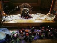 obraz hlavy Ježiša a pekne naaranžované ruže pod oltárom