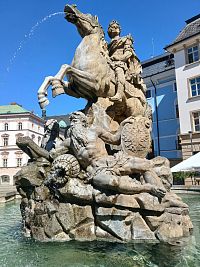 jazdec na koni, pod ním socha muža, ktorá symbolizuje jednu z riek Maoary a Dunaj