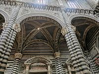 čierno biele obloženie, hore sochy pápežov a kráľov