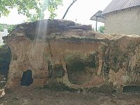 skalné obydlie za ním kamenný domček, dnes už neobývaný