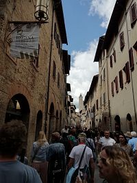 ulička stredovekých 2-3 poschodových domov, na prízemí s malými obchodíkmi