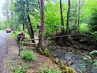 studnička, voda preteká trubkou a potom pri ceste padá do žľabu a potom odteká do potoka