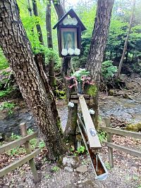 studnička skrášlená obrázkom Panny Márie a živými kvetmi