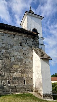 loď kostol z kamenných kvádrov a oporné piliere a veža nanovo omietnuté