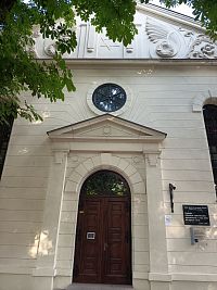 pekný vstup do synagógy so štítmi a guľatým oknom