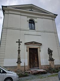 čelná stena kostola a socha Jána Nepomuckého a kamenný kríž pred kostolom
